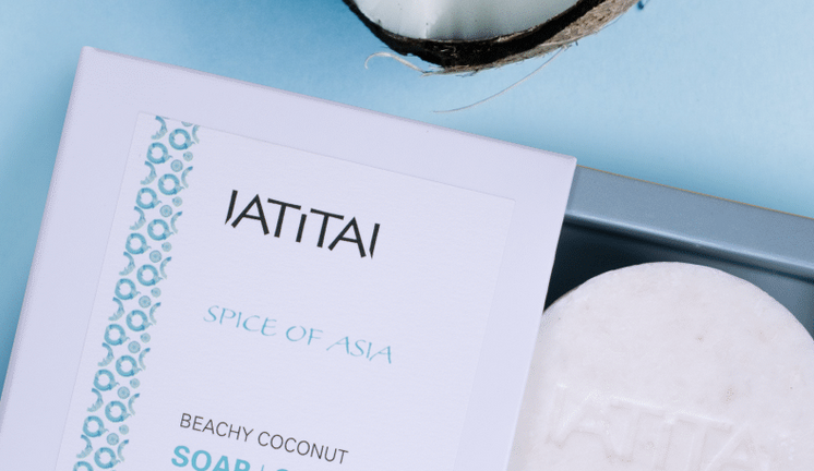 Hautpflege mit Kokos: IATITAI Kokos Seife auf blauem Untergrund für Hautpflege im Sommer